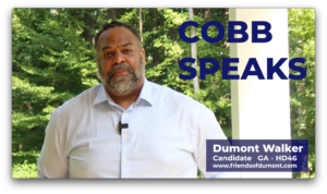 A screen grab of a man in a white button up shirt with a microphone clipped on. The words Cobb Speaks is visible in the top left corner and a title card in the lower left says Dumont Walker, Candidate GA HD 46 with a campaign url below it.