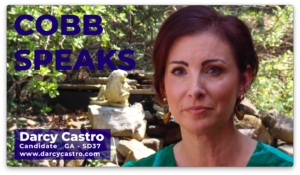 A screen grab of a video showing a woman with short hair. In the top left are the words Cobb Speaks. In the bottom left corner, is a box with the words Darcy Castro, Candidate Ga SD37 with a link to a campaign website underneath.