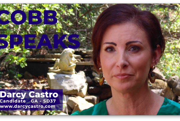 A screen grab of a video showing a woman with short hair. In the top left are the words Cobb Speaks. In the bottom left corner, is a box with the words Darcy Castro, Candidate Ga SD37 with a link to a campaign website underneath.